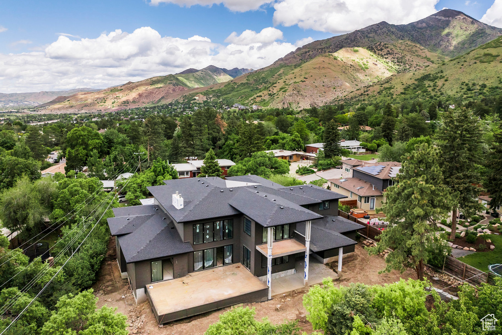 Aerial view of property and surrounding area featuring a mountain backdrop