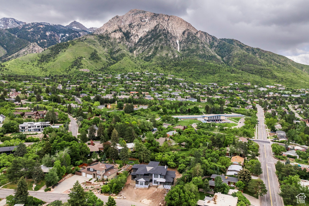 Aerial view of property and surrounding area with a mountainous background and nearby suburban area
