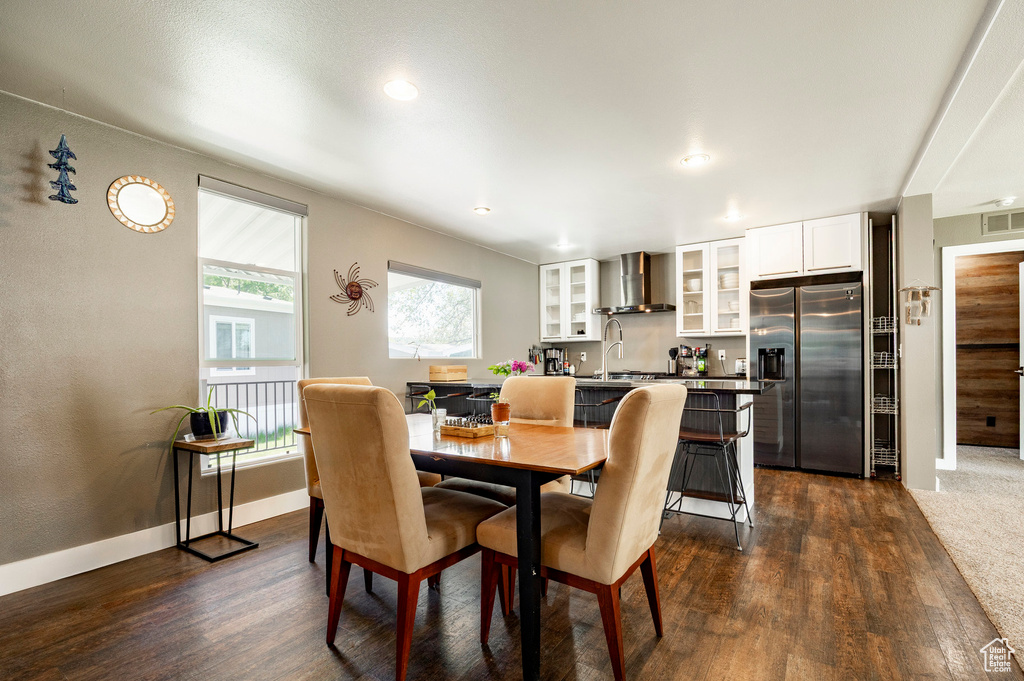 Dining space with dark wood-type flooring, baseboards, and recessed lighting