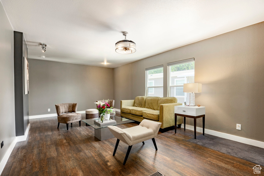 Living room with dark wood-type flooring and baseboards