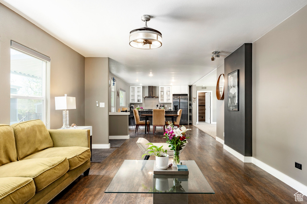 Living room with baseboards, dark wood-type flooring, and healthy amount of natural light