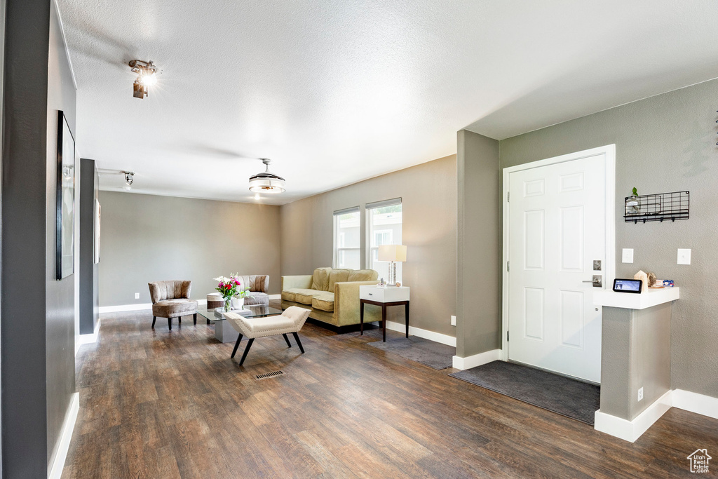 Living area featuring dark wood finished floors and baseboards