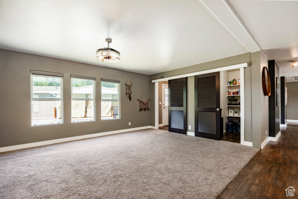 Unfurnished living room with baseboards and wood finished floors