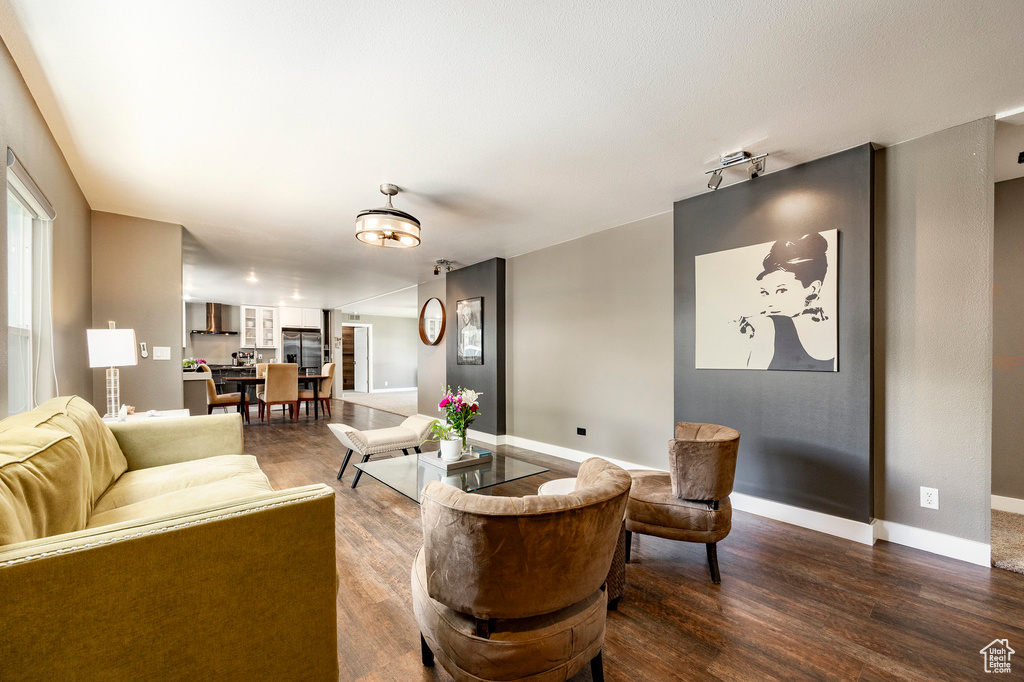 Living room featuring dark wood-style flooring and baseboards