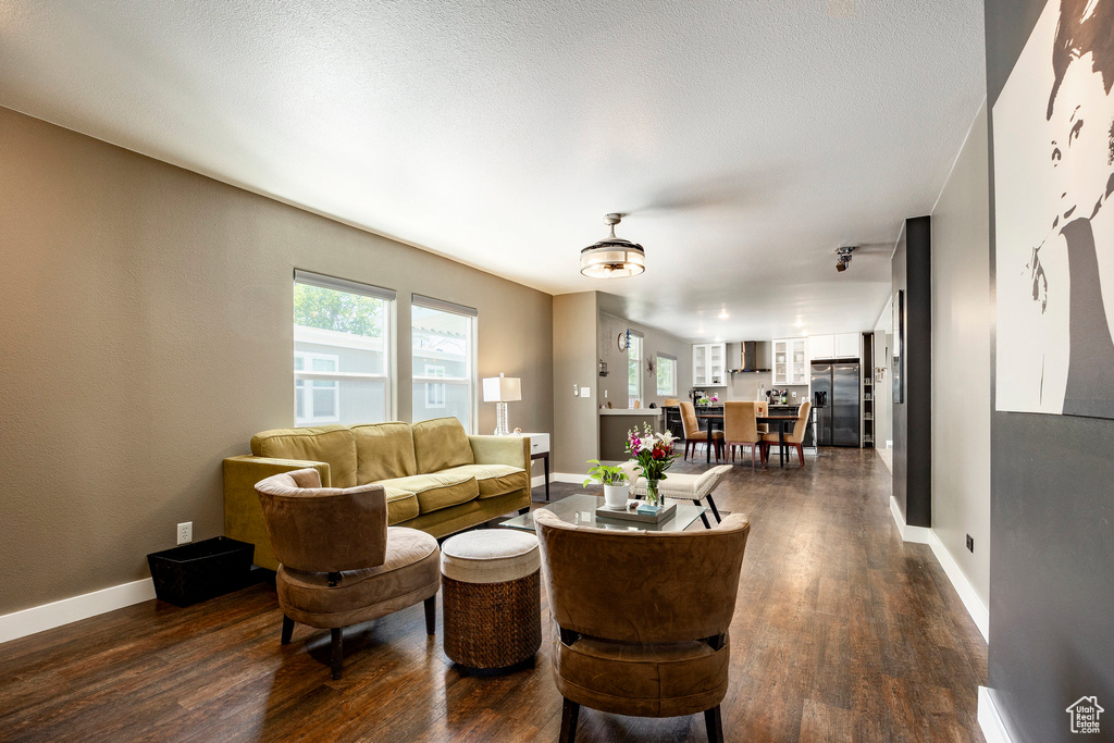 Living area with dark wood-style flooring and baseboards