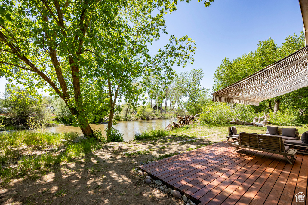 Wooden terrace featuring an outdoor hangout area and a water view
