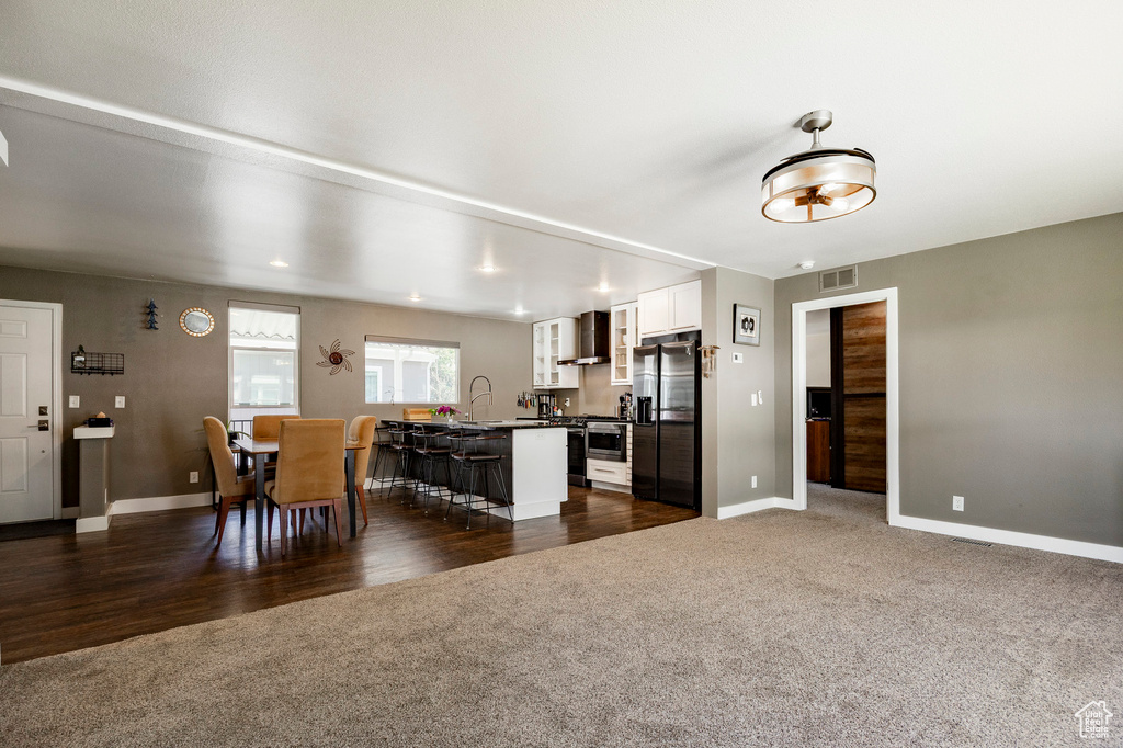 Dining room featuring dark colored carpet and baseboards