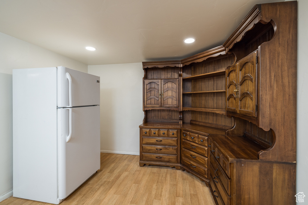 Kitchen featuring freestanding refrigerator, baseboards, dark countertops, open shelves, and light wood finished floors