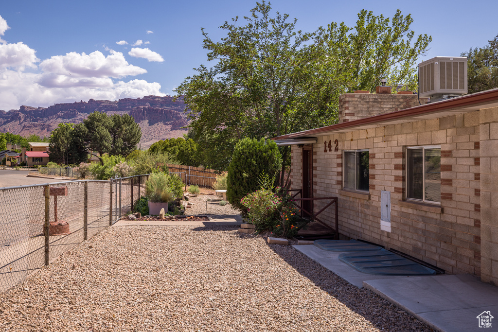 Fenced backyard featuring cooling unit and a mountain view