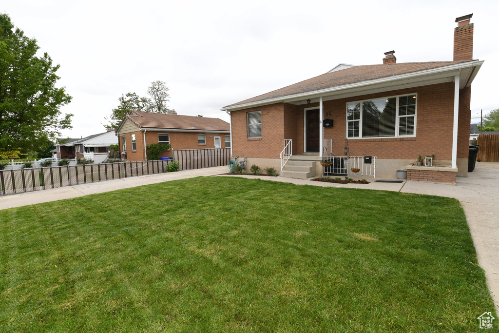View of front of home with brick siding and a chimney