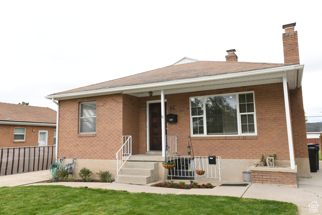 Bungalow with brick siding and a chimney