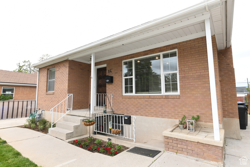 View of front of property with brick siding and fence