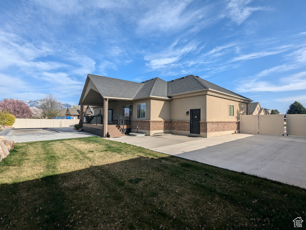 Back of house with brick siding, stucco siding, and a patio area