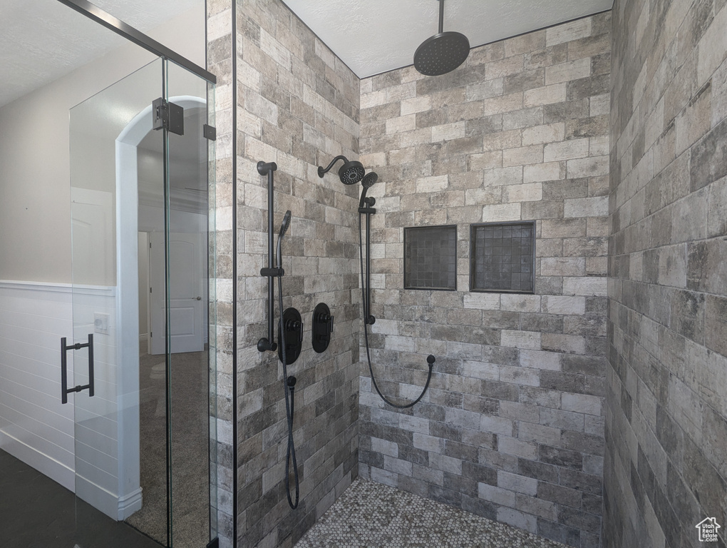 Full bath featuring a stall shower and wainscoting