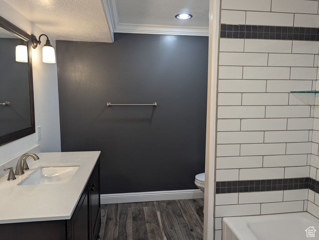 Full bath featuring wood finished floors, toilet, vanity, baseboards, and recessed lighting