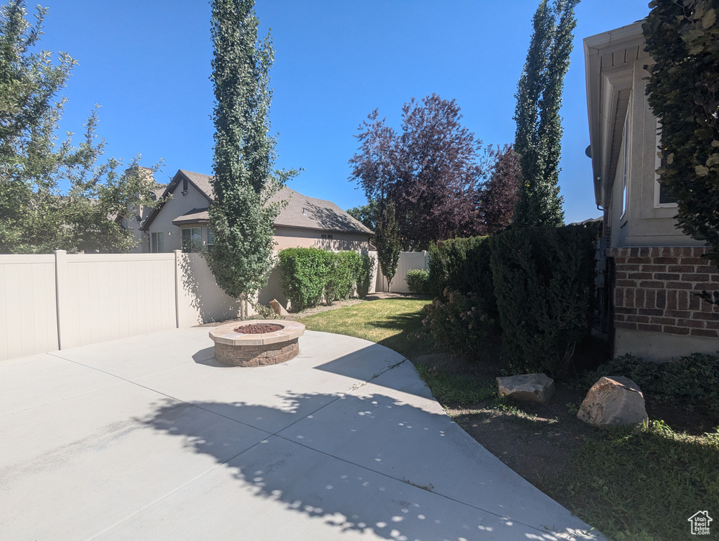 Fenced backyard with a fire pit and a patio