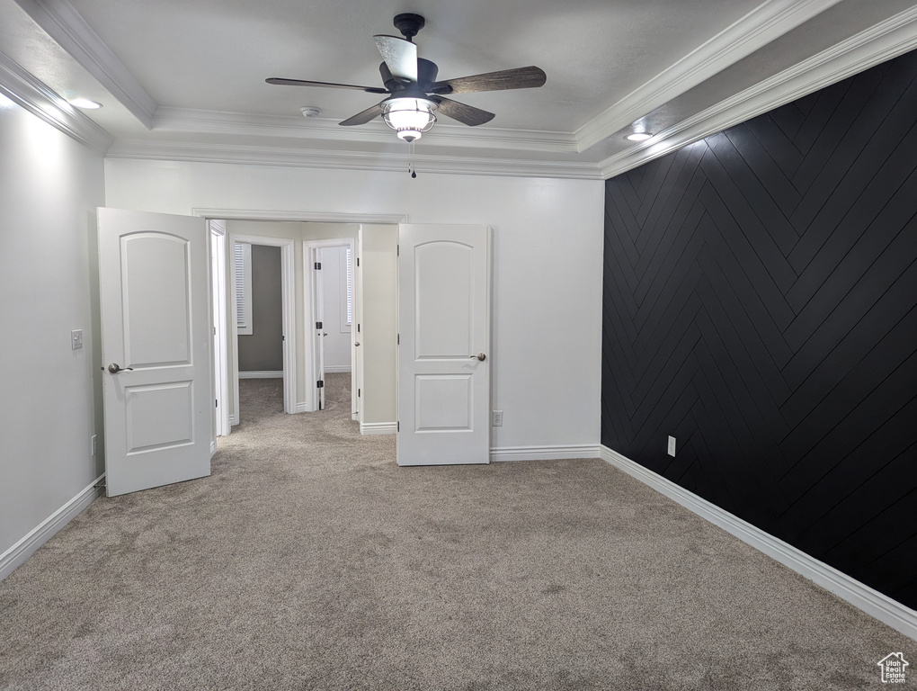 Empty room with light carpet, a ceiling fan, ornamental molding, and baseboards