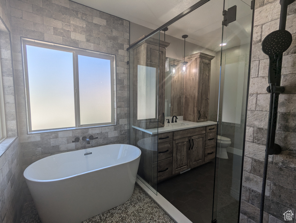 Bathroom featuring vanity, a freestanding tub, a shower stall, tile patterned floors, and tile walls