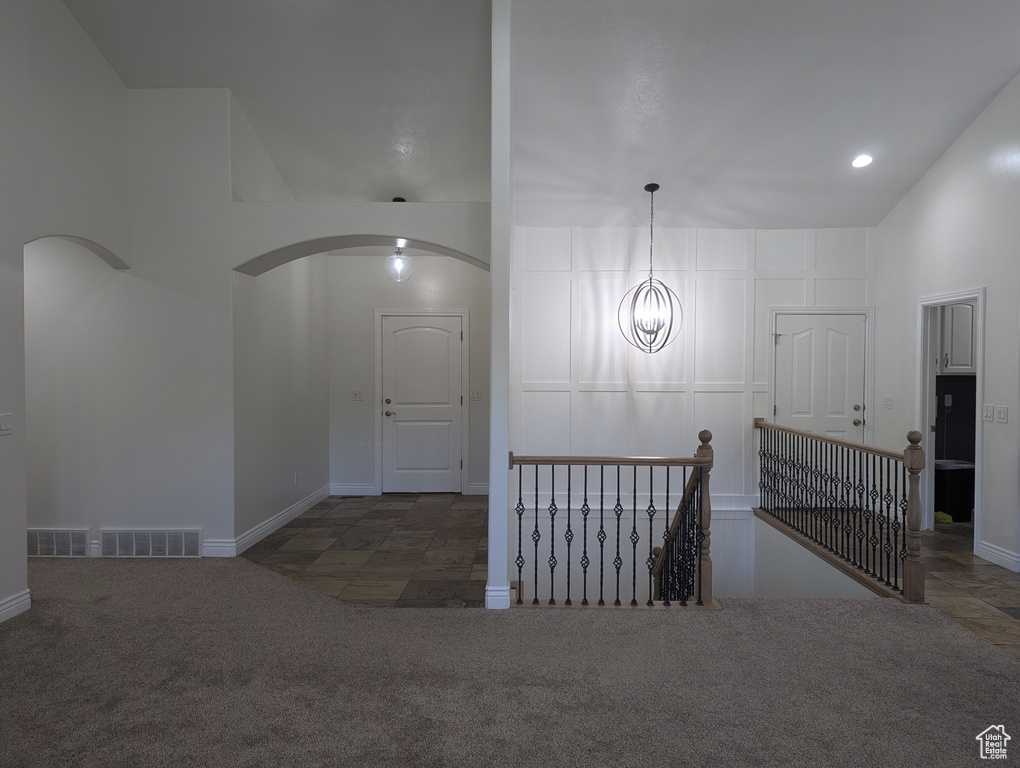 Hallway featuring arched walkways, an upstairs landing, carpet floors, and recessed lighting