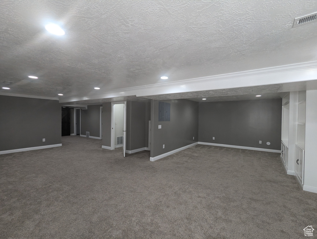 Finished below grade area featuring crown molding, recessed lighting, carpet, and a textured ceiling