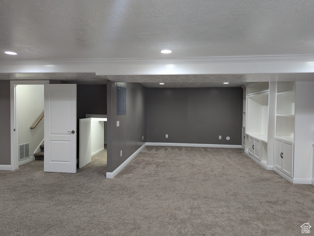 Finished basement featuring crown molding, carpet, a textured ceiling, baseboards, and recessed lighting
