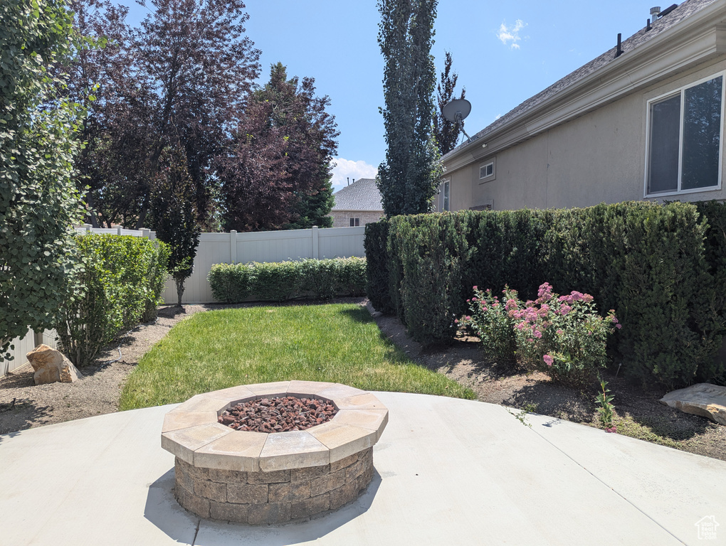 Fenced backyard featuring a patio and an outdoor fire pit