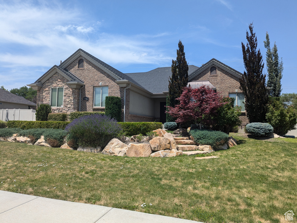 View of front of property featuring brick siding and a front yard