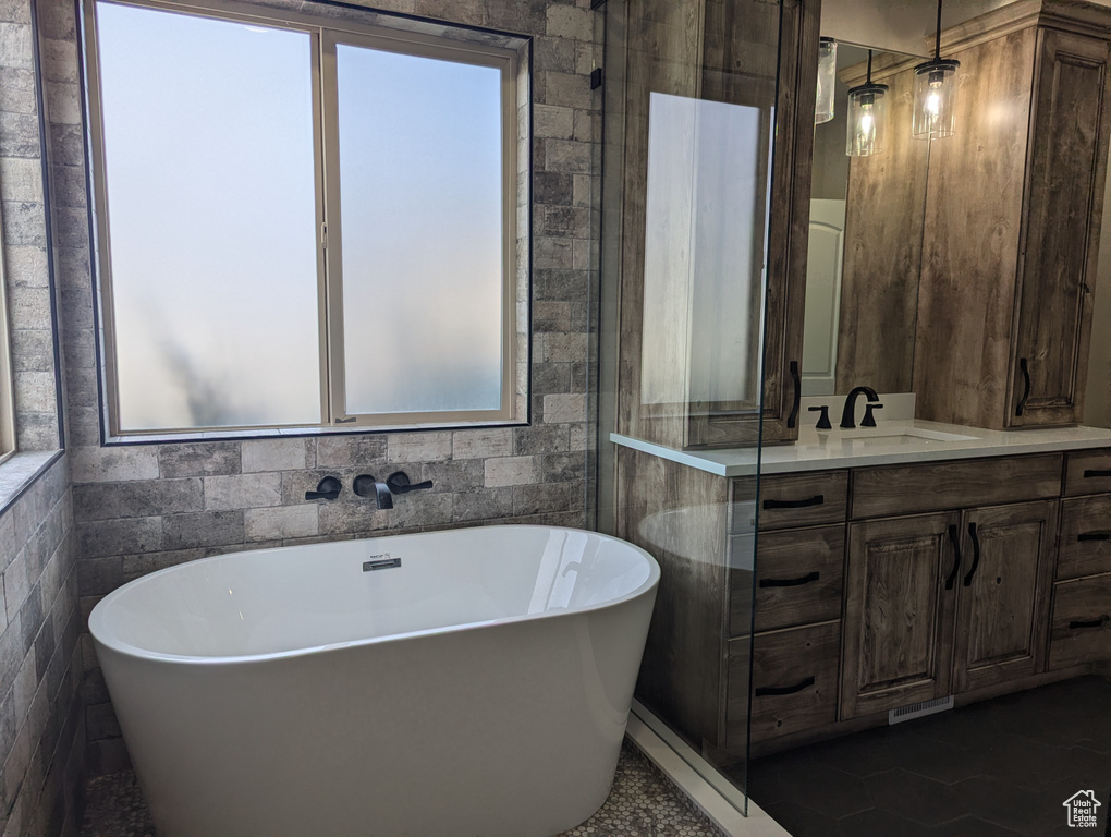 Full bath featuring a soaking tub and vanity