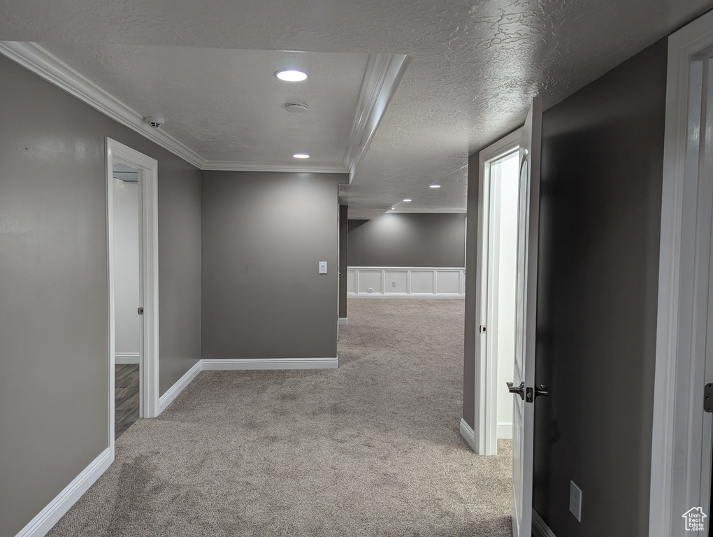 Hallway featuring carpet floors, ornamental molding, recessed lighting, baseboards, and a textured ceiling