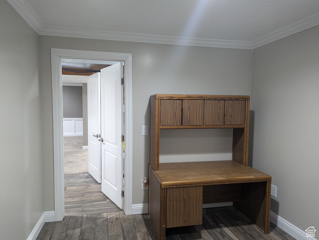 Corridor with dark wood-style flooring, crown molding, and baseboards