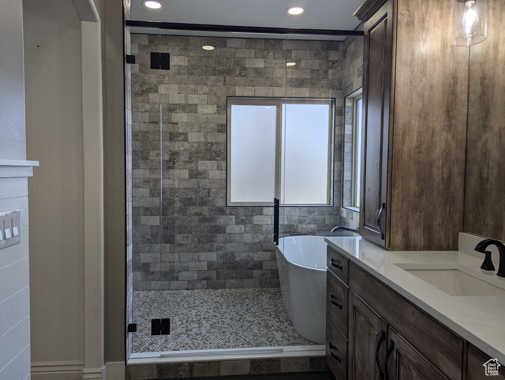 Bathroom with a freestanding bath, recessed lighting, a shower stall, and vanity