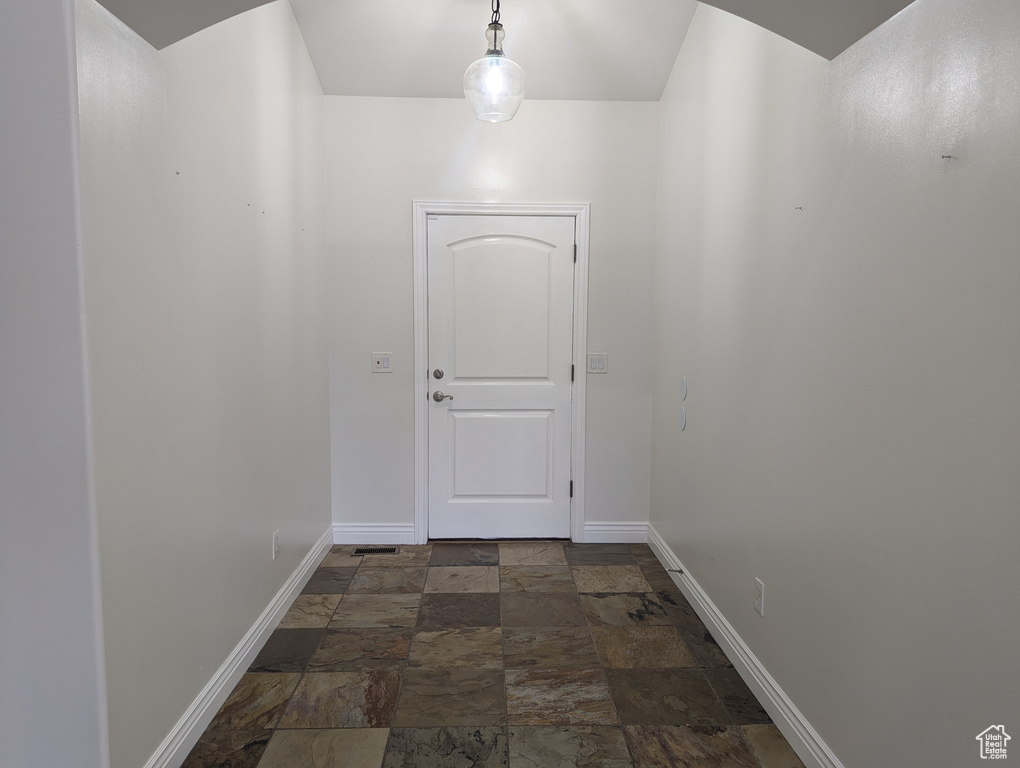 Hallway with baseboards and stone finish floors