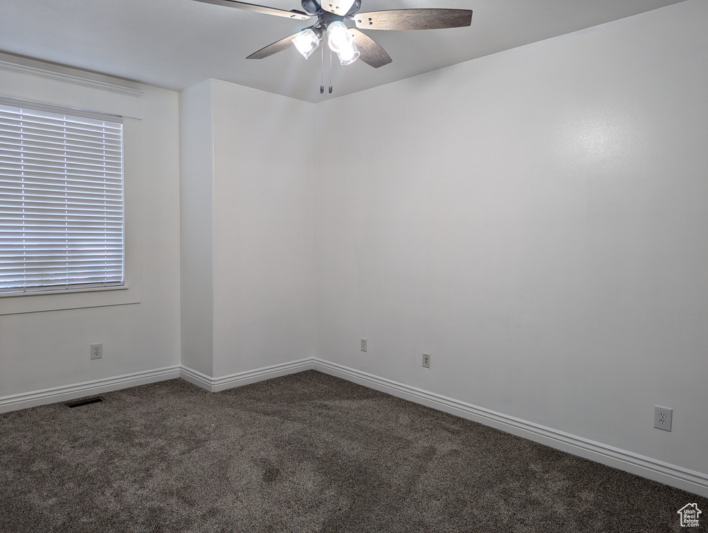 Spare room featuring carpet floors, ceiling fan, and baseboards