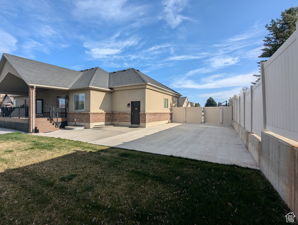 Rear view of house with a gate, brick siding, stucco siding, and a porch