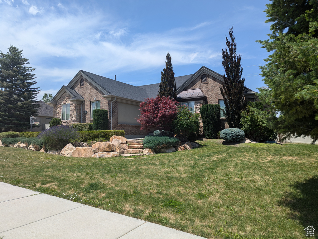 View of front of house featuring brick siding and a front yard