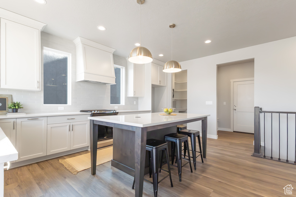 Kitchen featuring electric range, white cabinetry, a kitchen island, decorative backsplash, and recessed lighting