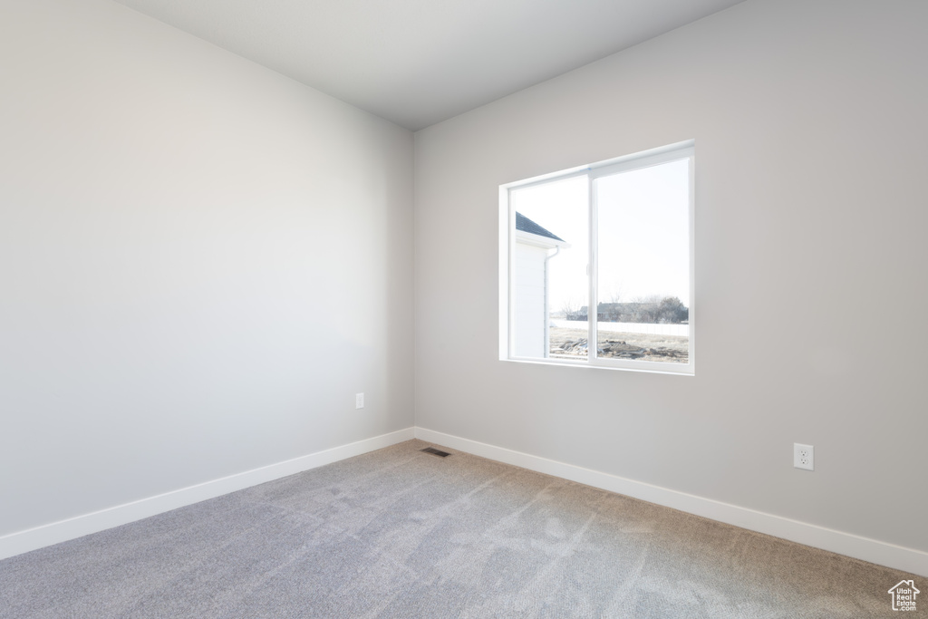 Spare room with light colored carpet and baseboards