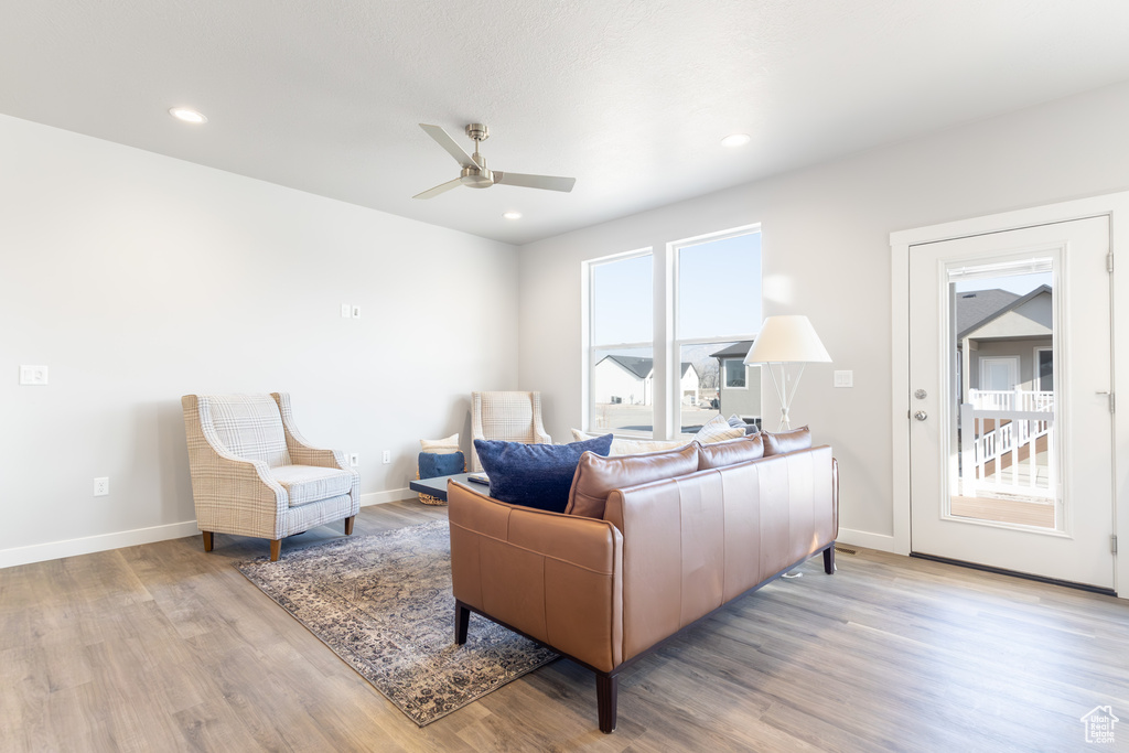 Living area with wood finished floors, ceiling fan, baseboards, and recessed lighting