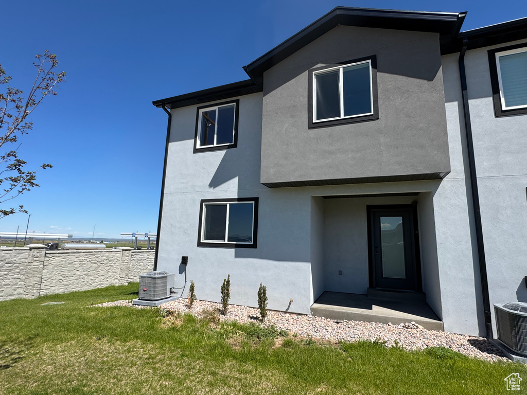 Rear view of property with stucco siding and central air condition unit