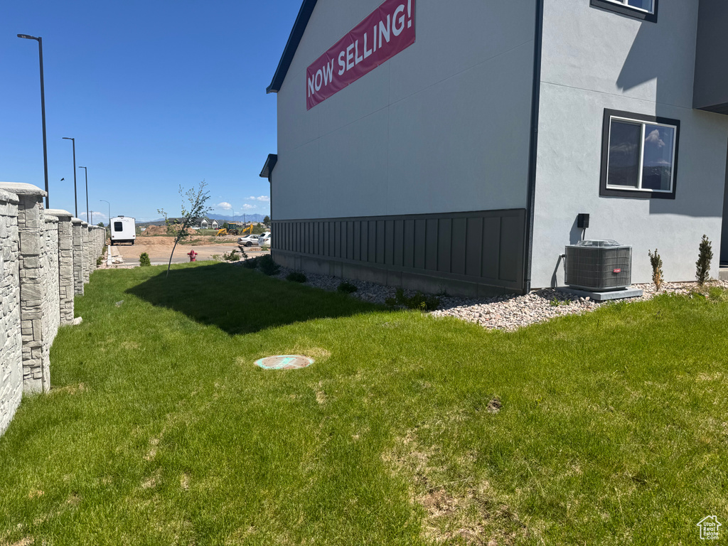View of grassy yard with central air condition unit