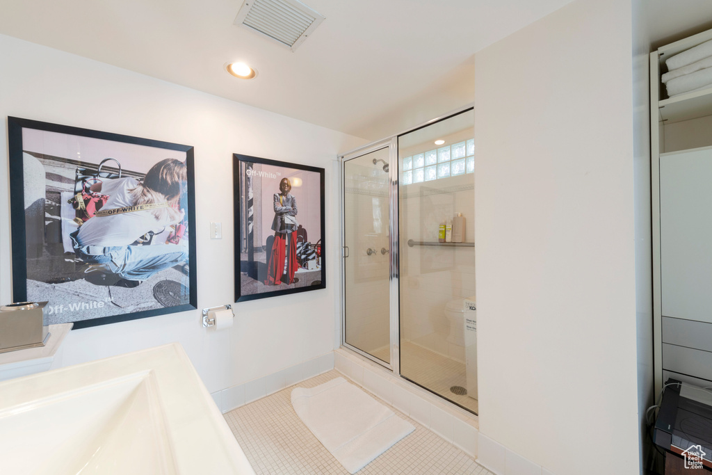 Bathroom with a shower stall, baseboards, tile patterned flooring, and recessed lighting