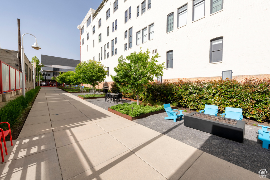View of community with an outdoor fire pit and a patio area