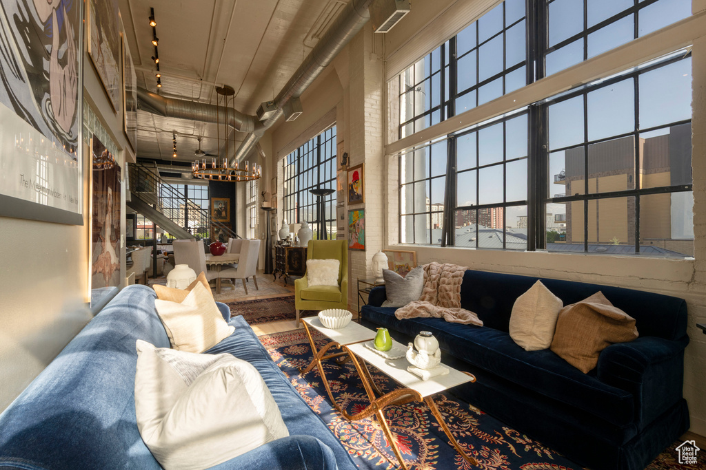 Living area featuring a towering ceiling, a chandelier, and wood finished floors