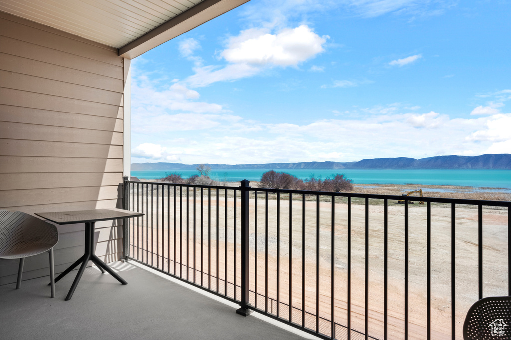 Balcony featuring a water and mountain view