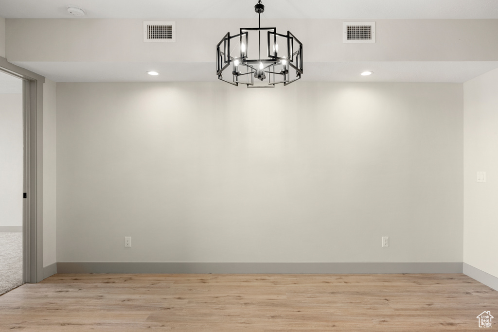 Unfurnished dining area with a chandelier, light wood-style floors, recessed lighting, and baseboards