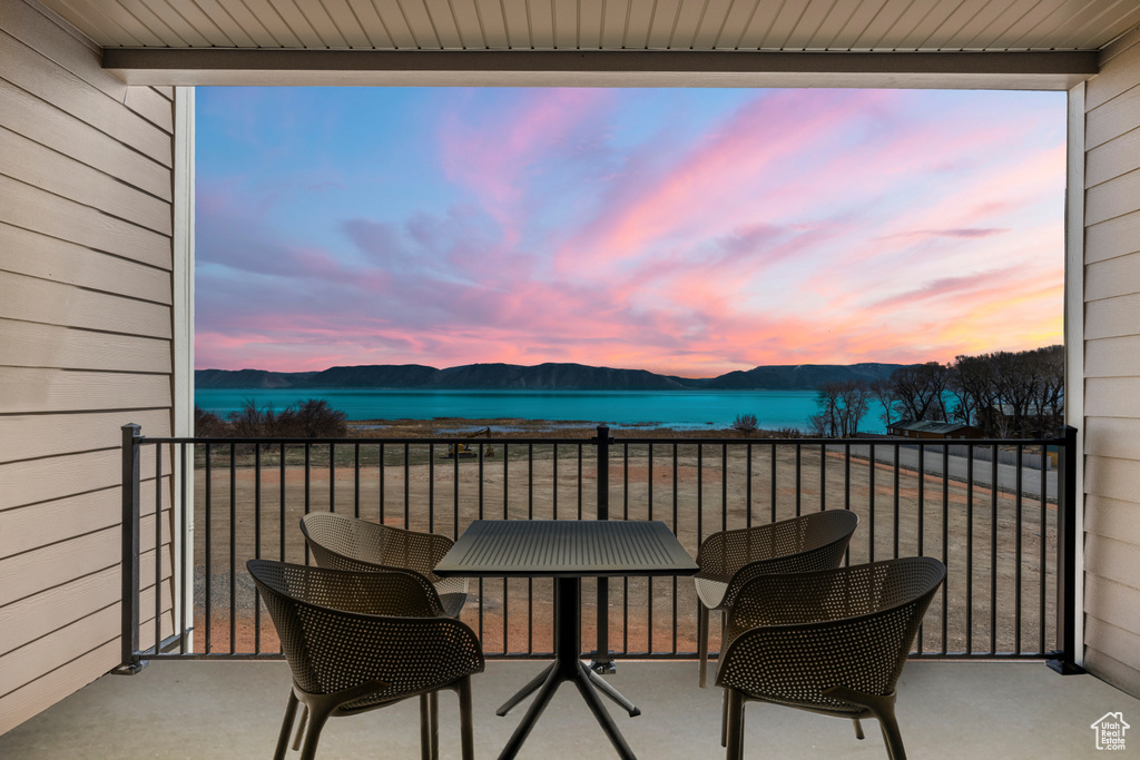 Balcony featuring a water and mountain view
