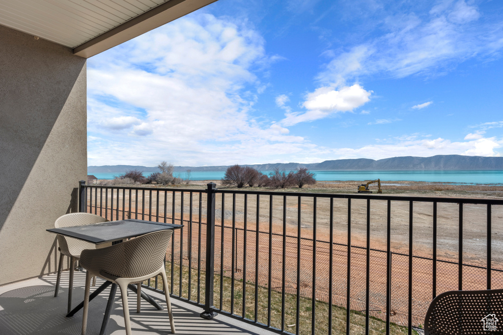 Balcony featuring a water and mountain view