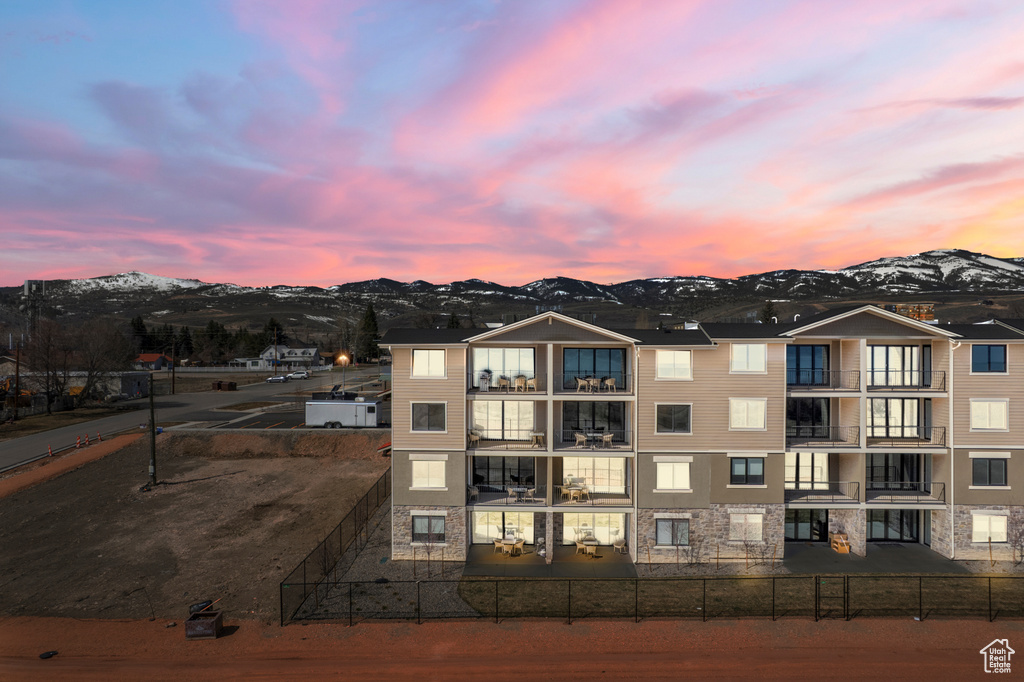 Property at dusk featuring a mountain view and a fenced backyard