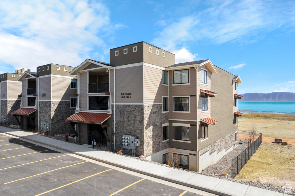 View of property featuring uncovered parking and a water view