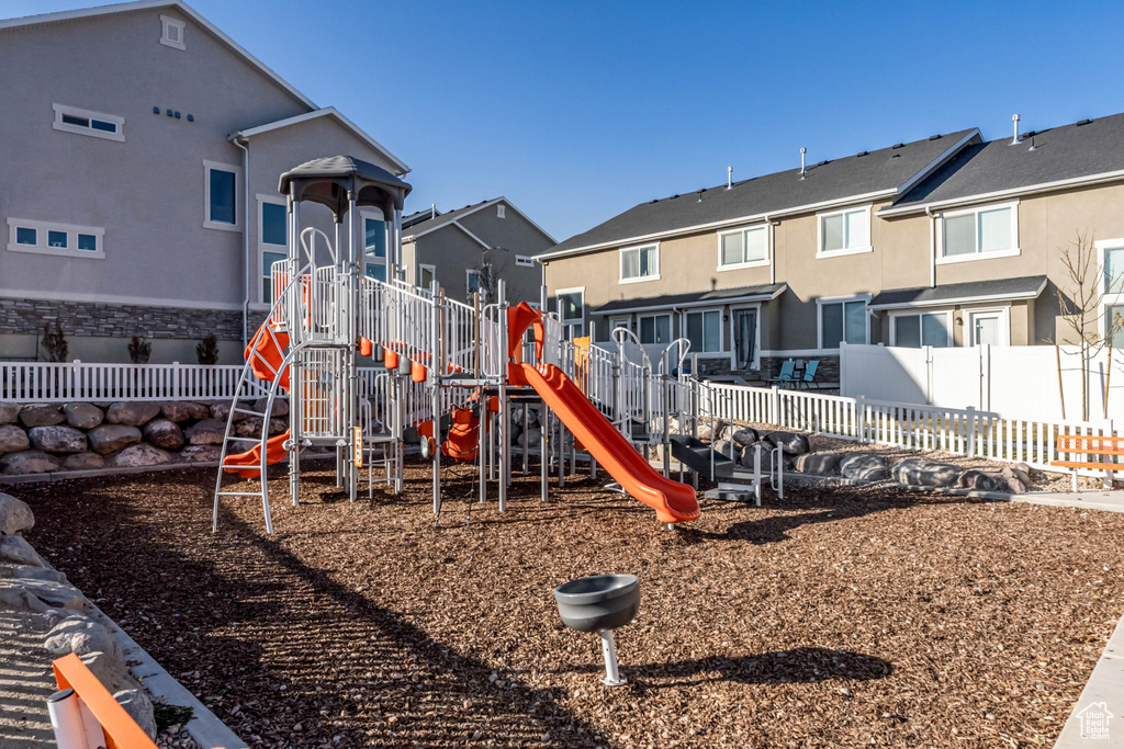 Community playground featuring fence and a residential view